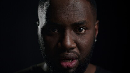 Fototapeta premium Shocked afro guy yelling indoors. Frustrated man looking at camera in studio