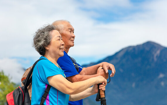 happy asian senior couple hiking in nature