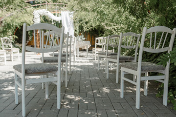 Fototapeta na wymiar Wedding ceremony with chairs and wedding arch from flowers.