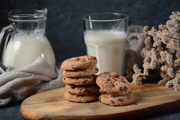 Chocolate chip cookies  with milk on wooden board 