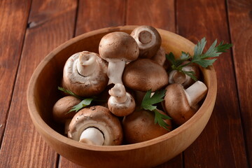Fresh brown champignon mushrooms on wooden board