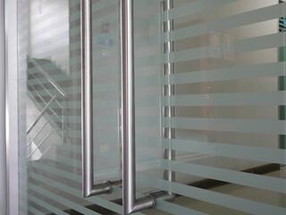 glass door with metal handles in office.
