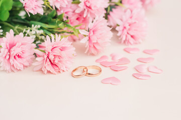 Pair of wedding rings surrounded by hearts and flowers