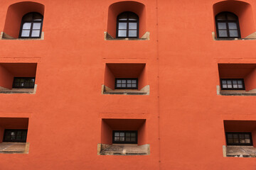 Fototapeta na wymiar Orange facade with small windows. Architectural background
