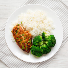 Homemade Chicken Breast, Rice and Broccoli on a white plate on a white wooden background, top view. Flat lay, overhead, from above. Close-up.