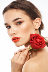 Fototapeta premium Beautiful woman with red rose near face makeup naked shoulders portrait