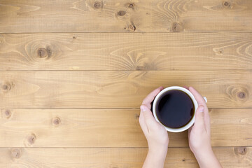 Minimalistic style woman hand holding a cup of coffee on pink background. Flat lay, top view