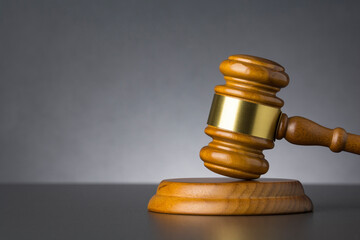 Wooden judge gavel against grey background , close up