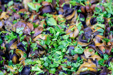 Side view of large pan with of freshly cooked mussels and parsley on display for sale at a street food festival, ready to eat healthy seafood.