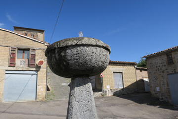 old stone fountain against a blue sky on a deserted square