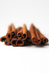 Loose cinnamon and cinnamon sticks on a white background. Cinnamon is used primarily for spices, imparting a spicy aroma to foods