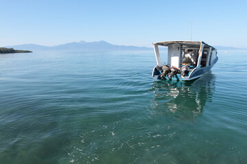 An empty motor boat on Sulawesi sea with Manadotua island on the background