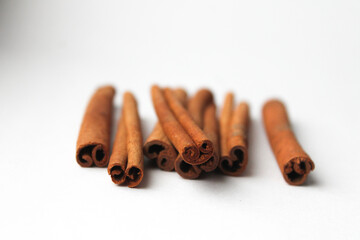 Loose cinnamon and cinnamon sticks on a white background. Cinnamon is used primarily for spices, imparting a spicy aroma to foods