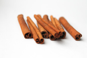 Loose cinnamon and cinnamon sticks on a white background. Cinnamon is used primarily for spices, imparting a spicy aroma to foods