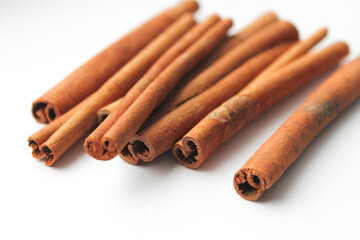 Loose cinnamon and cinnamon sticks on a white background. Cinnamon is used primarily for spices, imparting a spicy aroma to foods