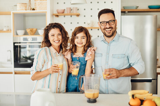 family child kitchen food daughter mother father orange juice healthy preparing drink breakfast together - Powered by Adobe