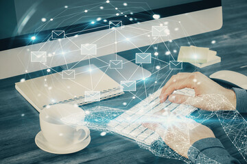 Envelop holograms with businessman working on computer on background. E-mail concept. Multi exposure.