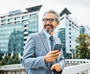 senior businessman office building mobile phone outdoor city smartphone communication gray hair