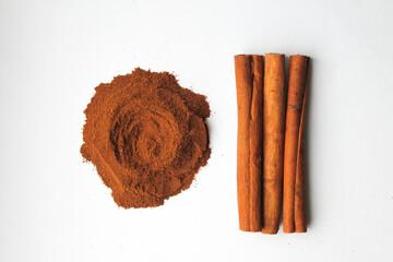 Loose cinnamon and cinnamon sticks on a white background. Cinnamon is used primarily for spices, imparting a spicy aroma to foods
