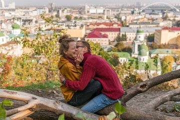 A couple enjoying time together outdoors in autumn, talking, laughing, kissing and hugging