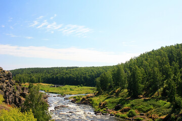 Fototapeta na wymiar The river flows among the green banks