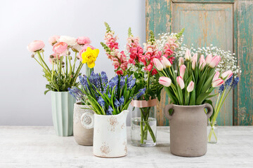 Beautiful muscari in ceramic jug and other spring flowers in the background.