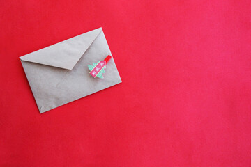 Paper envelope with a herringbone on a red background, close-up. Letter to Santa Claus.
