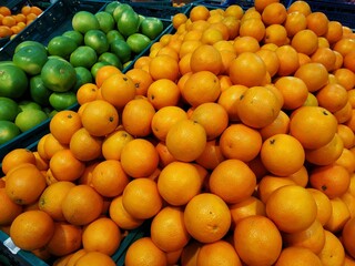 Organic and fresh oranges on fruit market, close up. Boxes full of ripe oranges for sale on farmers market. Fresh fruit display in shop.
