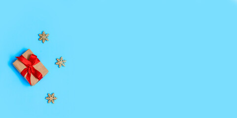 Banner. Christmas gift box tied with a red ribbon on a blue background with Golden snowflakes, Christmas and New year Greeting card