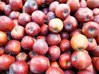Bunch  apples on boxes in supermarket. Apple put on sale shelves in the supermarket. Fresh ripe apples displayed beautifully. 