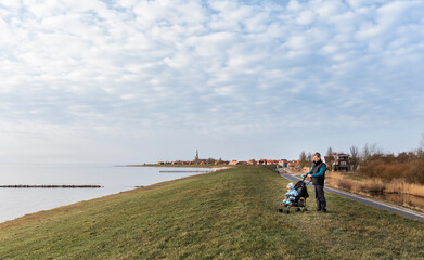 Mature man with toddler girl in stroller on dyke