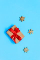 Christmas gift box tied with a red ribbon on a blue background with Golden snowflakes, Christmas and New year Greeting card