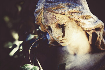 Death. Fragment of ancient statue of crying angel with tears in face as symbol of end of human life. Close up.