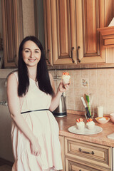 Cupcake with white cream decorated with strawberries in the hand of a woman in a pink dress