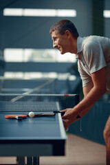 Man at the ping pong table, side view