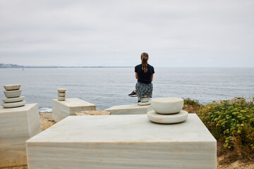Girl meditating looking to ocean