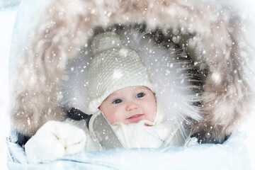 Baby in stroller in winter snow. Kid in pram.