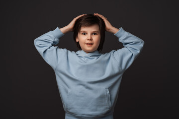 Image of shocked boy expressing surprise on camera. Studio shot, gray background. Facial expression concept