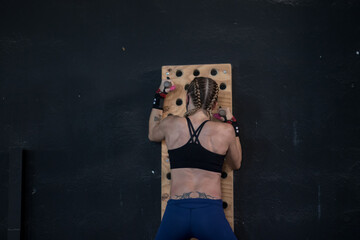 Chica con mascarilla en un gimnasio haciendo Cross training,  pegboard