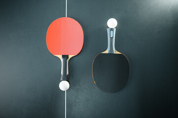 Ping pong balls and rackets at the net, top view