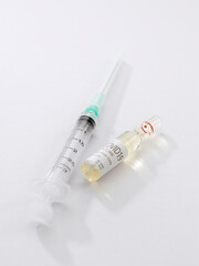 Close up view of the ampule with medicine and syringe on white back 