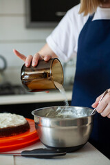 Young woman bakes a cake. Woman pouring sugar into a bowl. Cooking a cake step by step