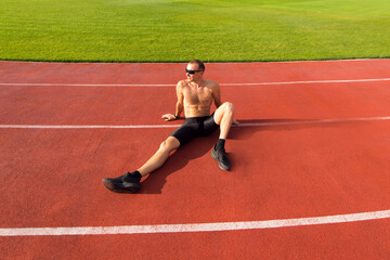 Obraz premium Runner resting on the track at the stadium