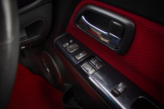 Сlose-up of the car black interior: the side door buttons: window adjustment buttons, door lock and other buttons.