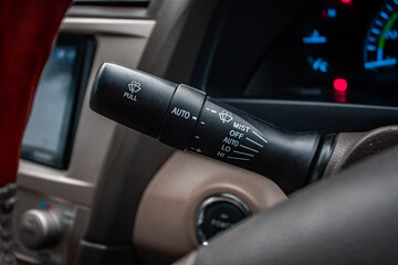 Obraz premium Windscreen wiper control switch in car. Wipers control. Modern car interior detail. adjusting speed of screen wipers in car.