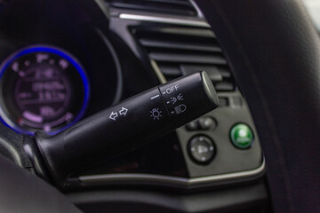 Switch off lights in a car. close-up Car integrated turning indicator with headlight switch toggle.