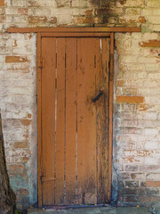 brown wooden door in a vintage brick wall
