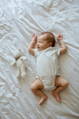 Cute newborn baby 3 weeks old lies on a white blanket. Baby goods packaging template. Closeup...