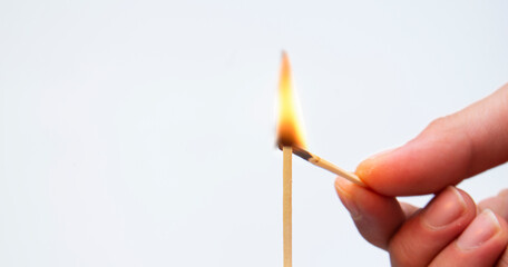 close-up hand burning match on isolated white background.