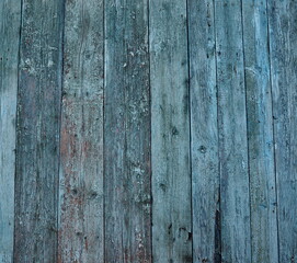 Fragment of old wooden wall cladding of a house in blue with peeling paint. Wooden natural background